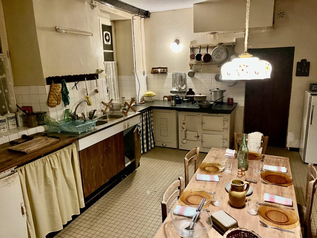 Décor de cuisine rustique pour tournage en Essonne (91). Cuisine de ferme authentique à Bruyères-le-Châtel, proche Paris. Équipée d'une cuisinière ancienne et d'un mobilier vintage, idéale pour films d'époque ou shooting photo en Île-de-France