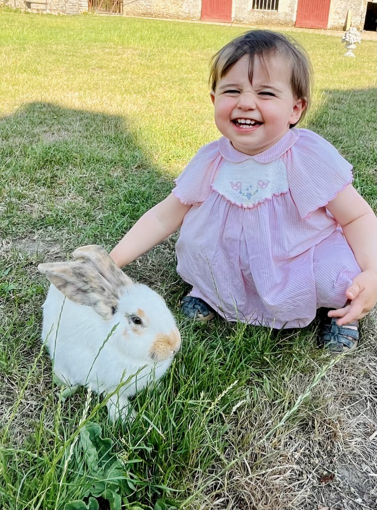 Enfant vivant un moment de complicité avec un lapin lors d'une visite à la Ferme de La Forêt, une activité idéale pour les familles en Essonne